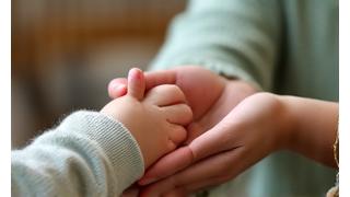Parent and child holding hands gently, indicating calm amidst parenting challenges.